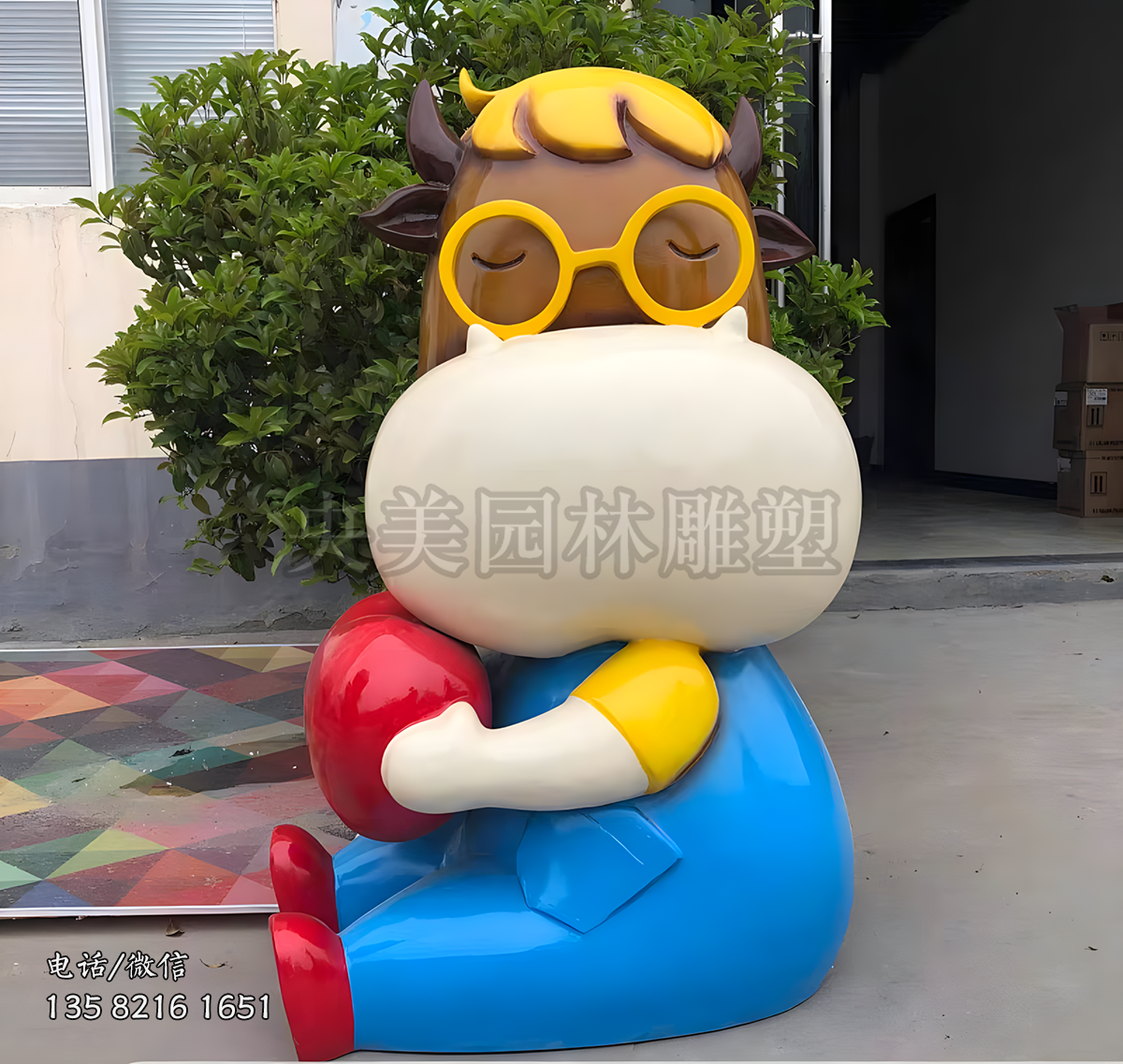 戴眼镜坐地上的卡通牛雕塑