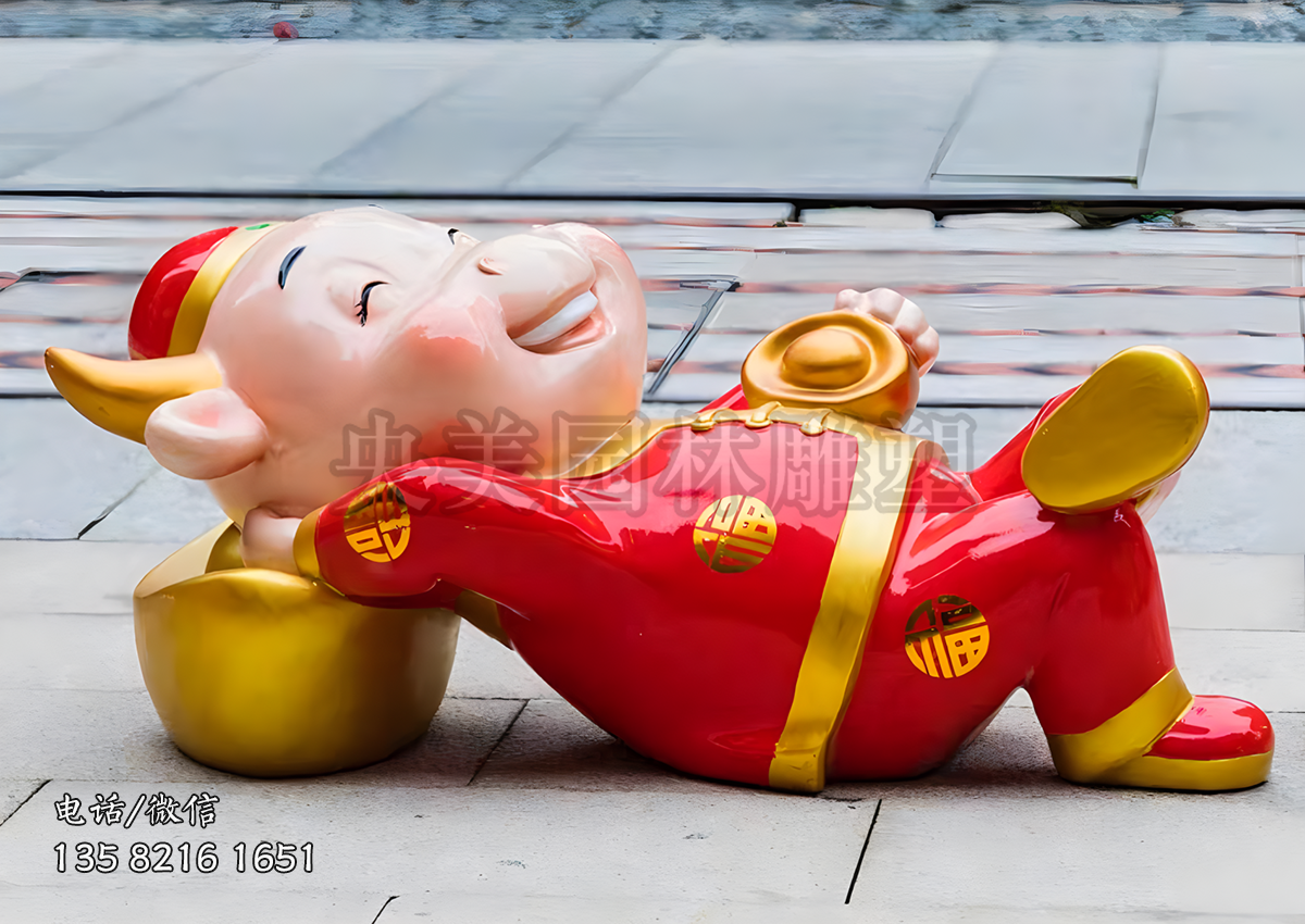 手抱元宝躺元宝上的牛年美陈卡通牛雕塑