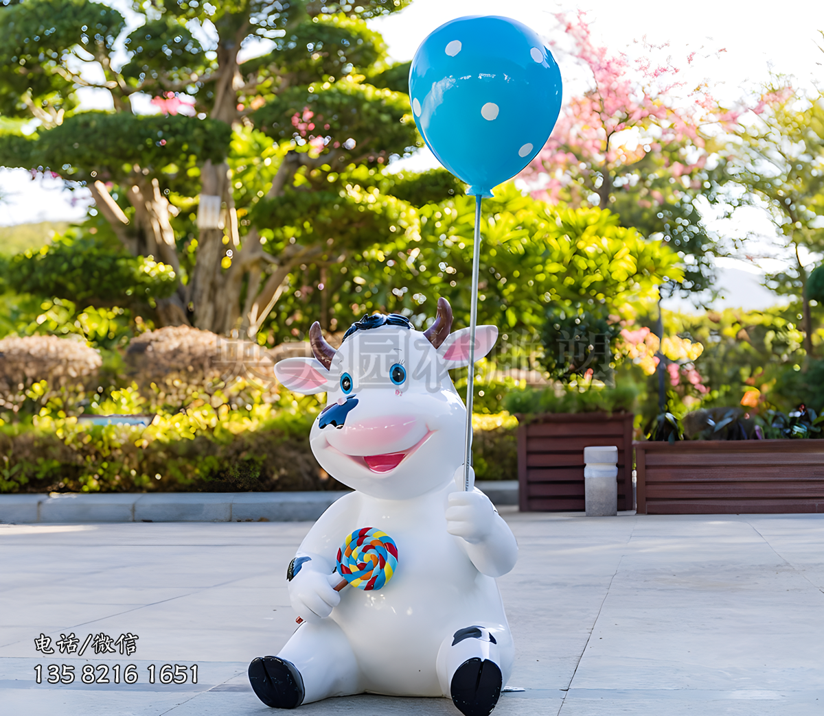 拿着气球和棒棒糖的卡通小奶牛雕塑