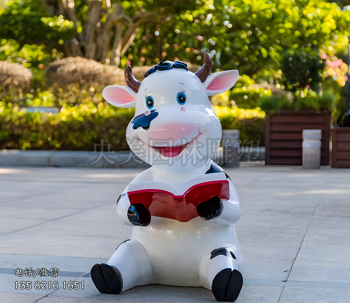 坐地上看书的卡通小奶牛雕塑